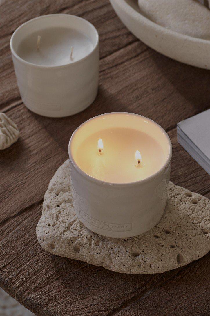 a candle on a table with a rock next to it