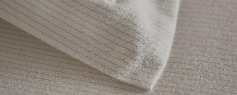 a close up of a man standing next to a bed