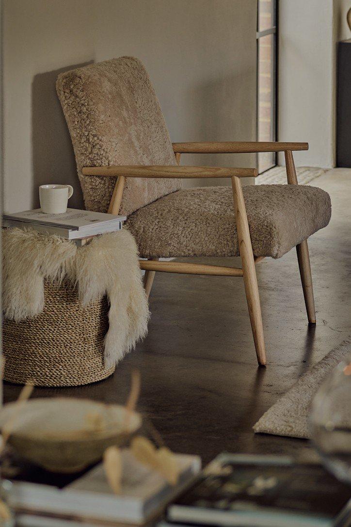 a chair and coffee table in a living room with a rug
