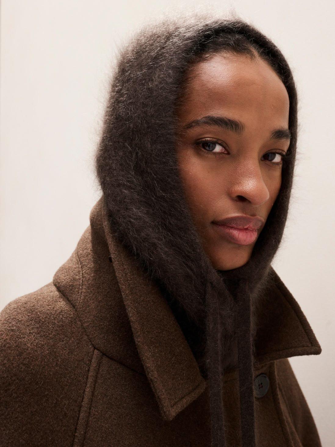 a woman wearing a hoodie and a scarf on her head