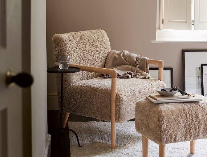 a living room with a chair and ottoman in a white room
