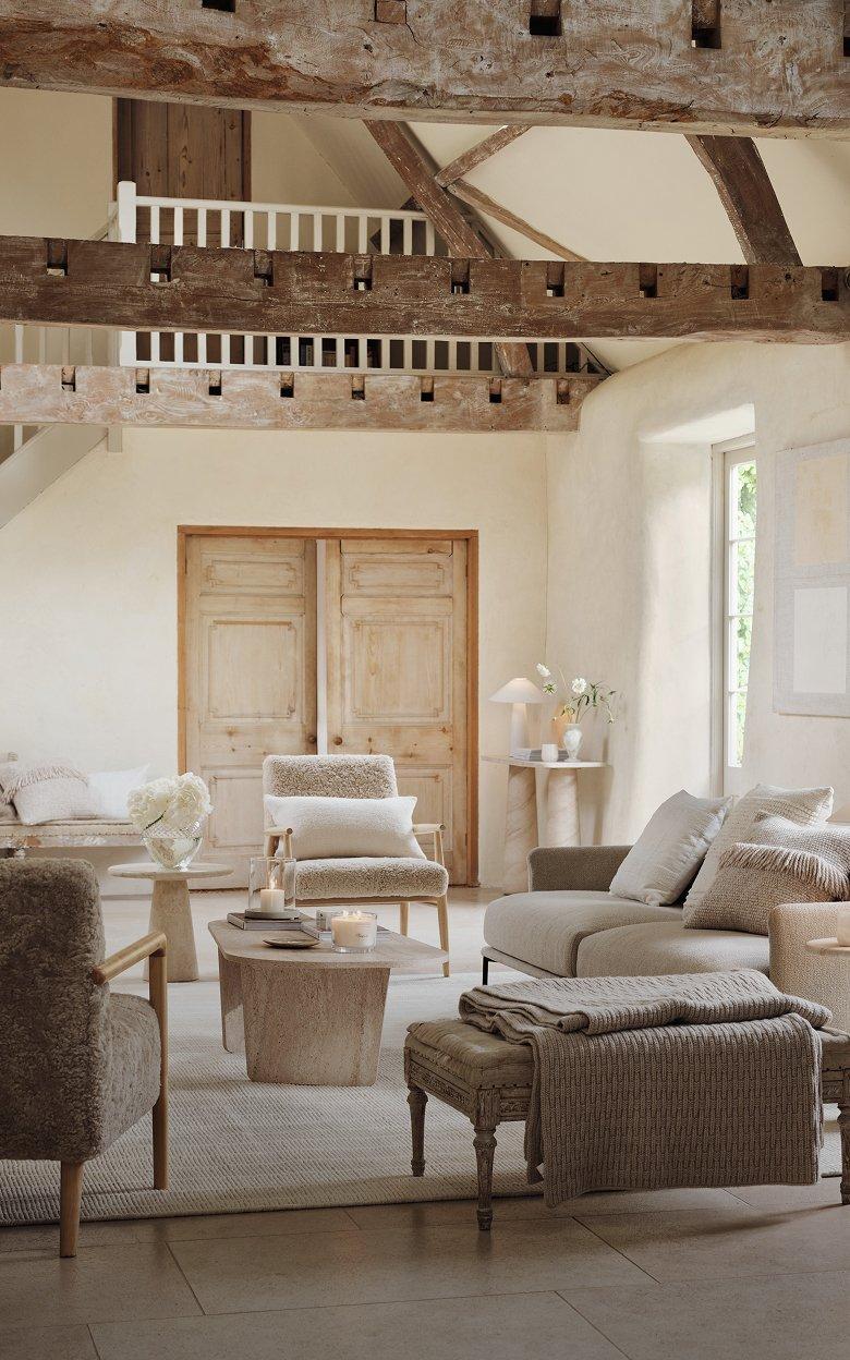 a living room with a large wooden beam ceiling and a white couch
